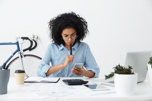 Frustrated young female entrepreneur in formal shirt and eyewear having a problem